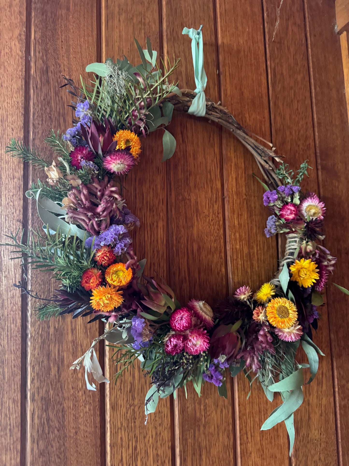 Floral wreath with colorful flowers on a wooden background